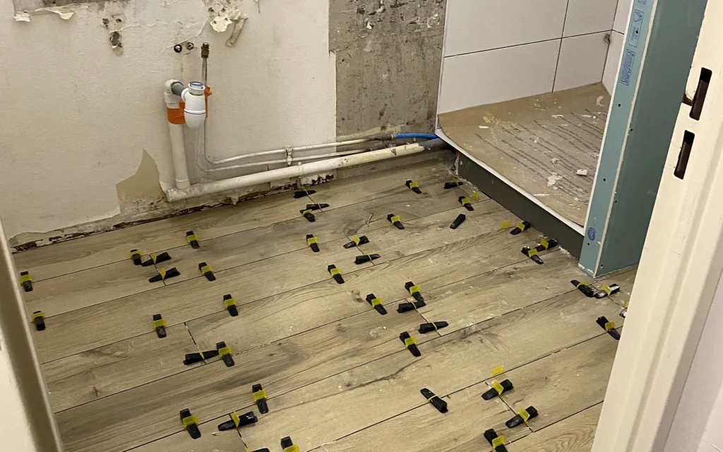 Salle de bains en cours de rénovation dans le centre de Rennes avec carrelage au sol en pose.