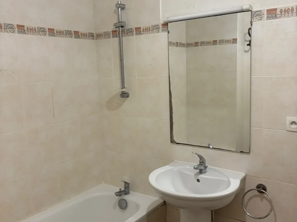 Salle de bains avant rénovation avec baignoire et lavabo sur pied